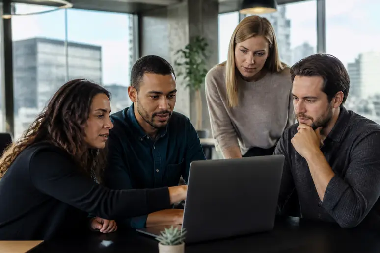Marketing professionals analyze SEOquake metrics on a laptop in a Denver co-working space, discussing how-to-use-seo-quake.