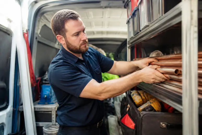 A plumbing technician organizing equipment inside a service van for local search optimization