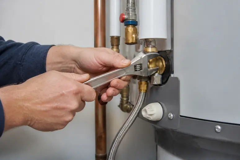 A plumbing professional repairing a residential water heater for local search execution