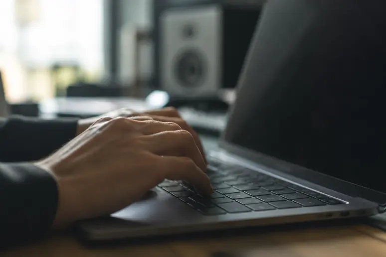 Developer typing JavaScript code to build interactive web art experiments on a screen