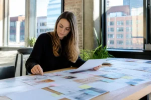 Content strategist reviewing printed marketing notes on a wooden table to grow instagram business page organically