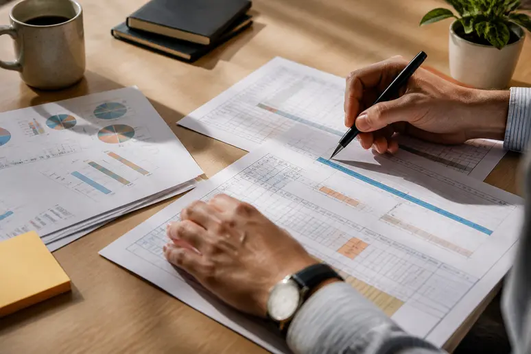 Digital marketing strategist organizing performance spreadsheets and campaign metrics during a comprehensive channel review
