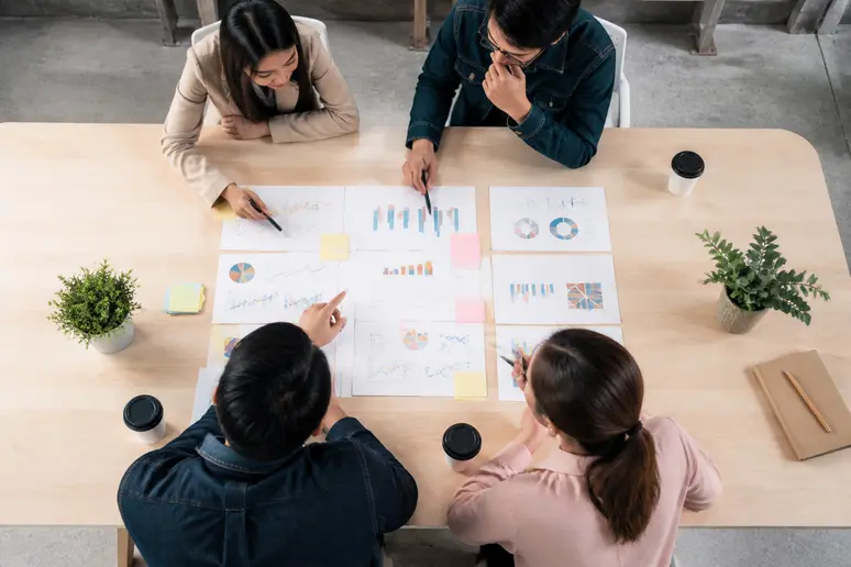 Marketing professionals reviewing competitive benchmarking data and operational roadmaps during an agency strategy session